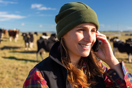 Woman on dairy farm with mobile phone to ear